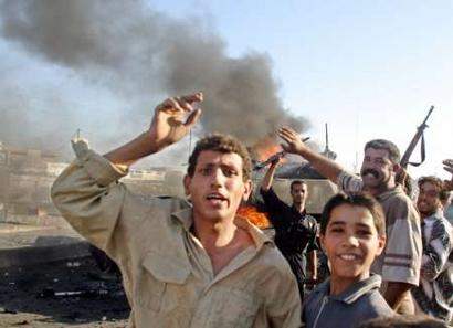 Iraqi youths chant a...